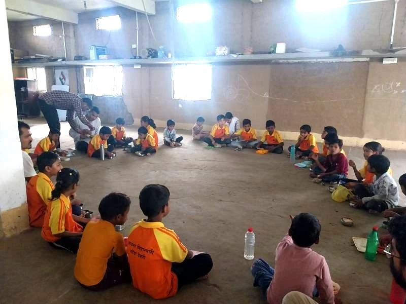 Children seated in community circle having lunch